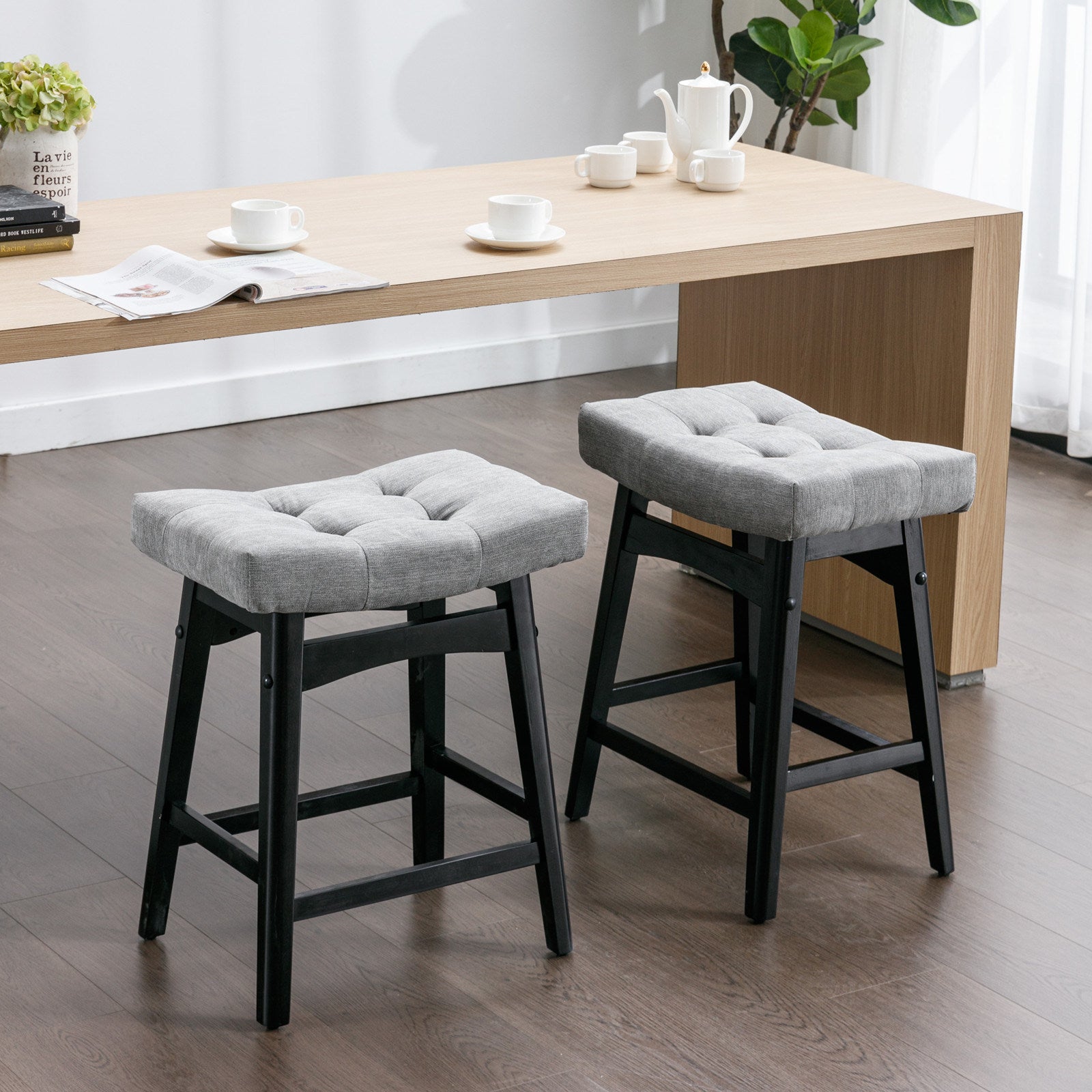 Two A&A Furniture, Counter Height 25" Stools for Kitchen Counter Backless Faux Leather Stools Farmhouse Island Chairs (25 Inch, Gray, Set of 2), SW1838GY in a room with a wooden table.