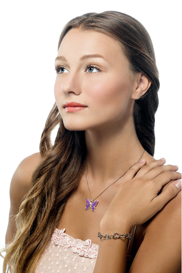 Young woman with braided hair wearing a pink dress and a 925 Sterling Silver Butterfly Necklace Handcrafted Pendant, looking away thoughtfully, isolated on a white background.