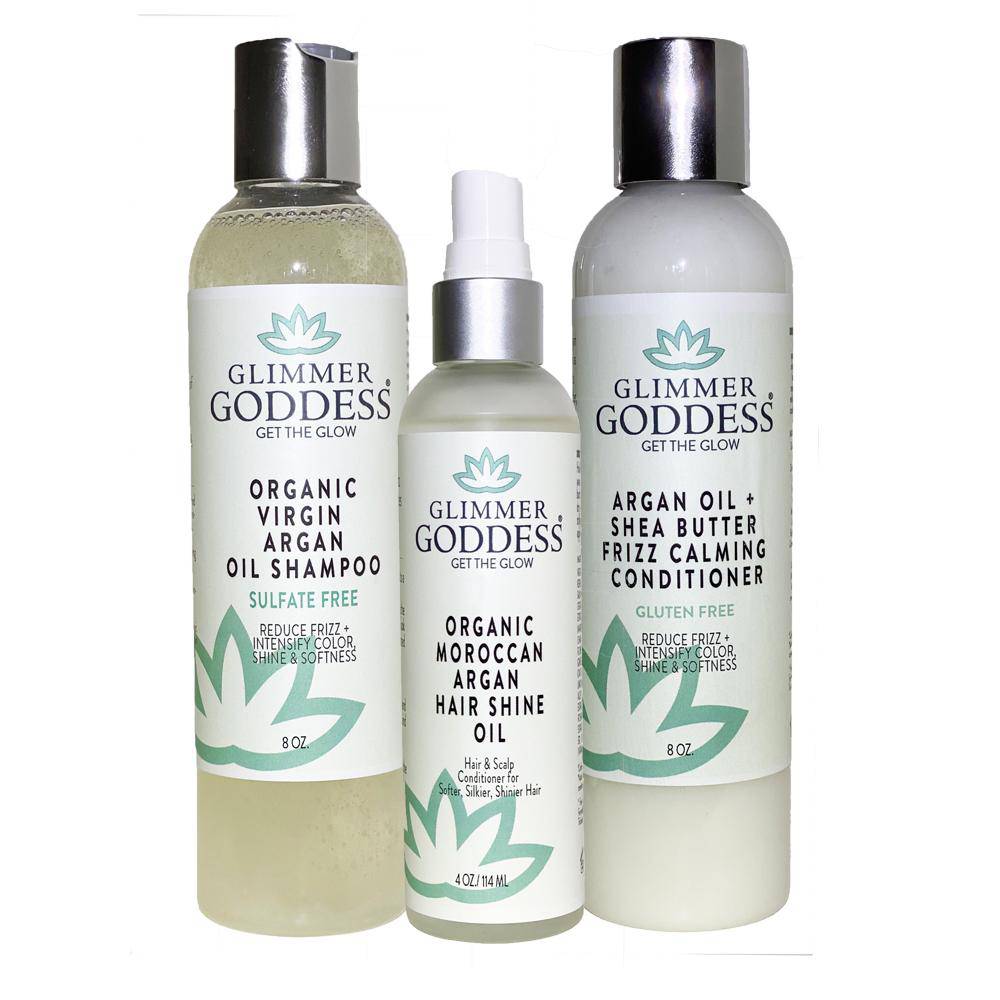 Three Organic Argan Oil Trio hair care products: Virgin Argan Oil Shampoo, Moroccan Argan Oil Hair Shine Spray, and Moroccan Argan Oil Shea Butter Conditioner, all in white and green bottles.