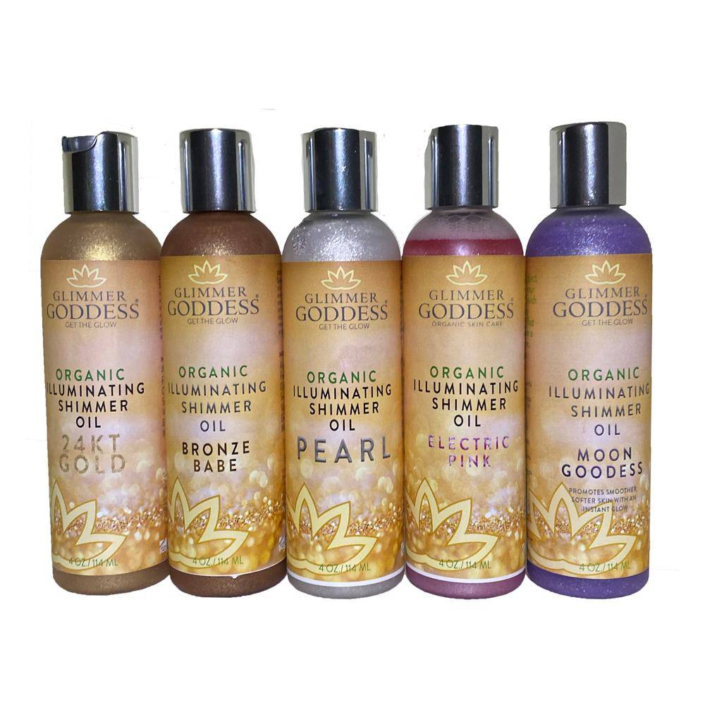 Five bottles of Illuminating Shimmer Body & Face Oils – Transform Your Skin, labeled gold, bronze babe, pearl, electric pink, and moon goddess, arranged in a row.